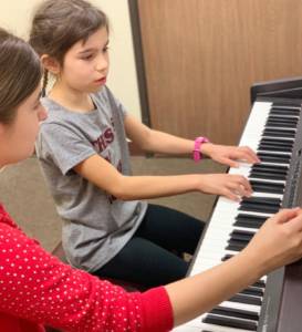 Boy and teacher taking a piano lesson