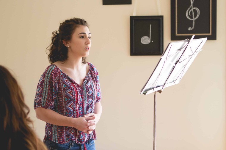 Female teenager taking singing lesson