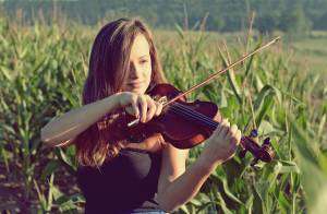 Teenage girl playing violin outside